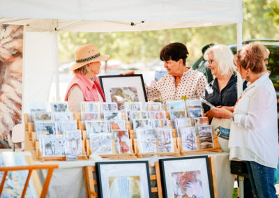 Ladies looking at artworks at market stall